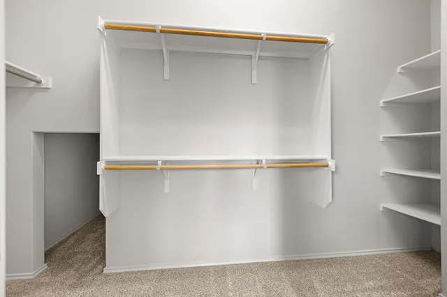 a view of walk in closet with empty racks