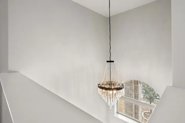 a view of a room with a chandelier fan