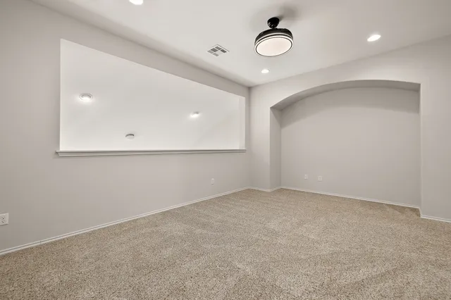 an empty room with wooden floor and fan