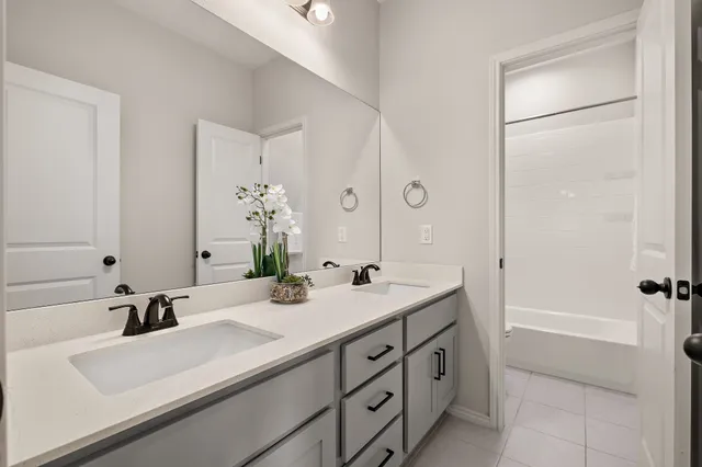 a bathroom with a double vanity sink mirror double and shower