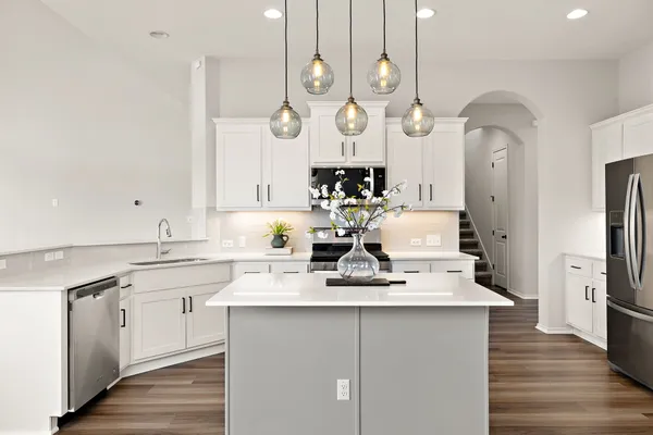 a very nice looking kitchen with granite countertop a sink cabinets and stainless steel appliances
