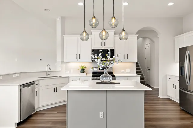 a very nice looking kitchen with granite countertop a sink cabinets and stainless steel appliances