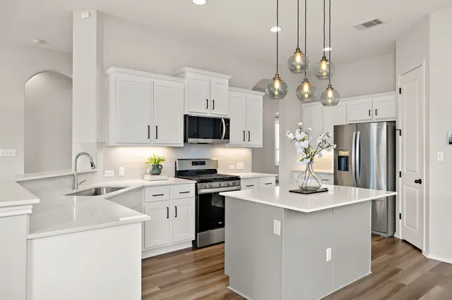 a kitchen with a sink a counter top space and stainless steel appliances