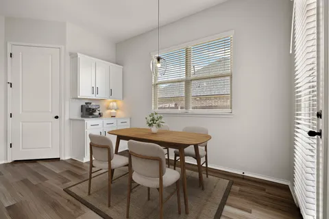 a kitchen with stainless steel appliances a table and chairs in it