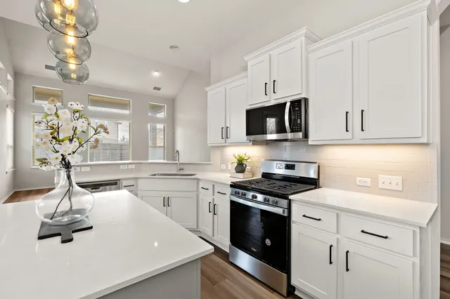 a kitchen with kitchen island granite countertop a sink stainless steel appliances and cabinets