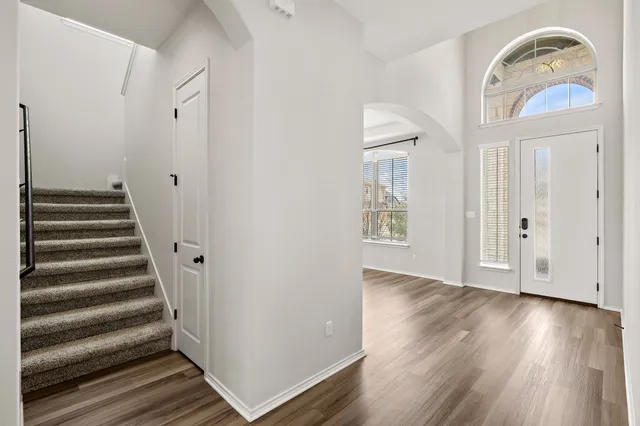 a view of a hallway with wooden floor and entryway
