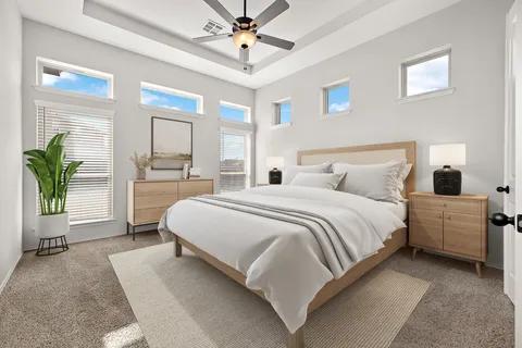 a bedroom with a large bed and a chandelier fan