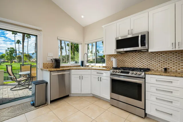 a kitchen with granite countertop cabinets stainless steel appliances and a sink
