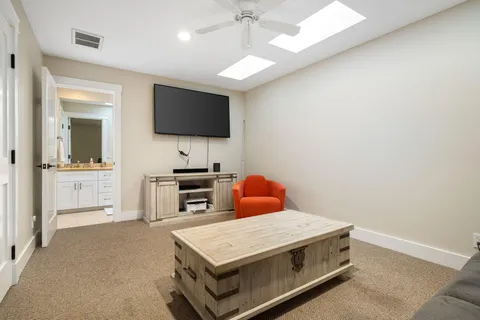 a living room with stainless steel appliances furniture and a flat screen tv