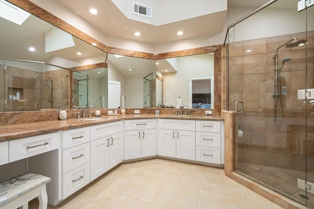 a bathroom with a granite countertop sink mirror and shower