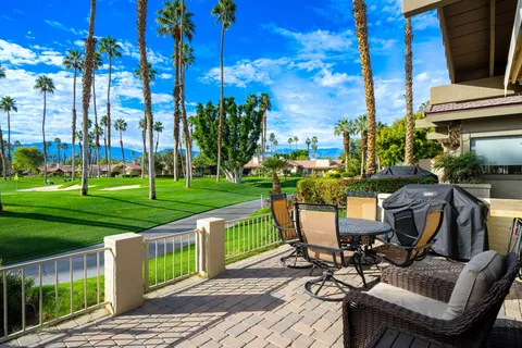 a view of a chairs and table in patio with a yard