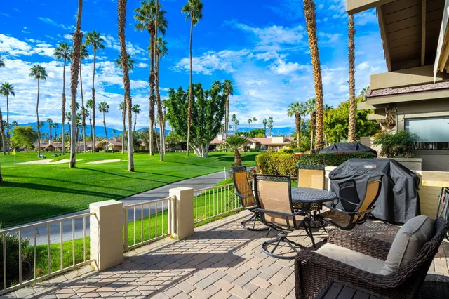 a view of a chairs and table in patio with a yard