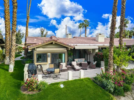a view of a patio with table and chairs potted plants and a large tree