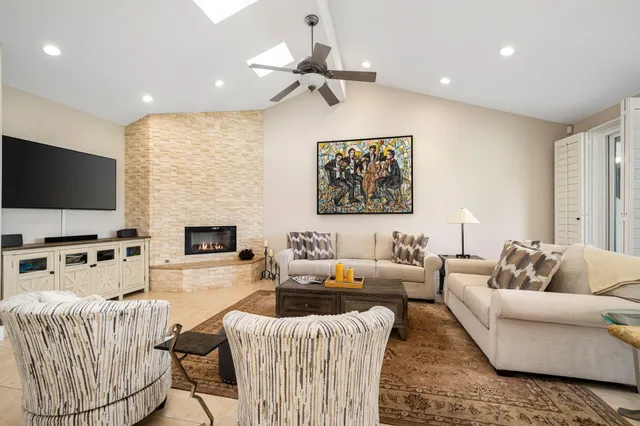 a living room with furniture a fireplace and a flat screen tv