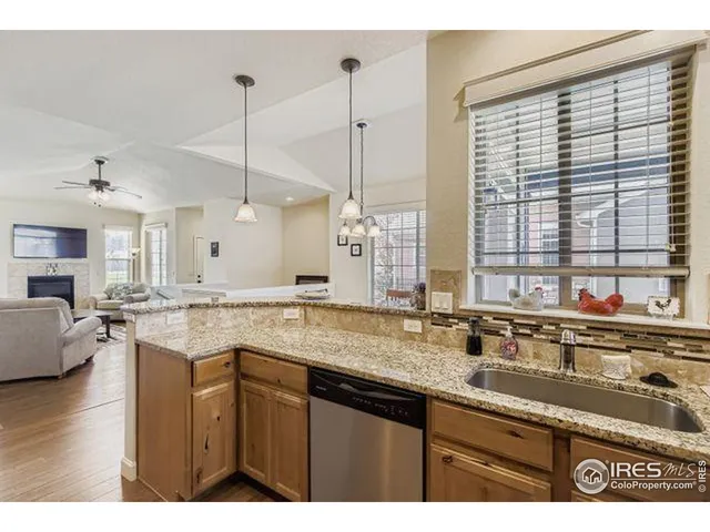 a kitchen with stainless steel appliances granite countertop a sink a stove and a wooden cabinets