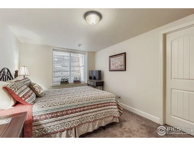 a bedroom with a bed and a large mirror