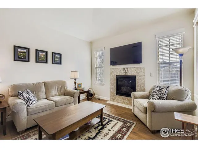 a living room with furniture a flat screen tv and a fireplace