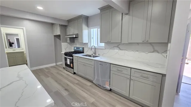 a kitchen with a sink cabinets and wooden floor
