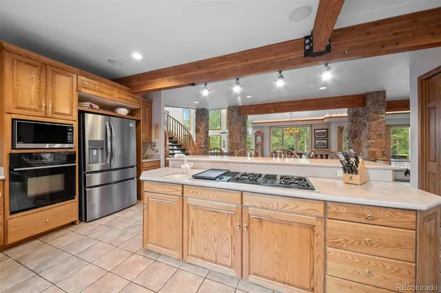 a kitchen with kitchen island granite countertop appliances cabinets and a counter space