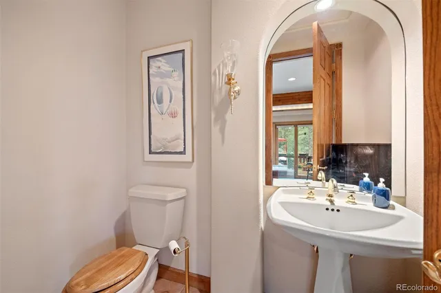 a bathroom with a sink a toilet and mirror