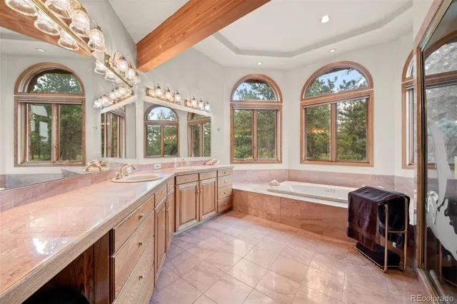 a large spacious bathroom with a large window and a chandelier