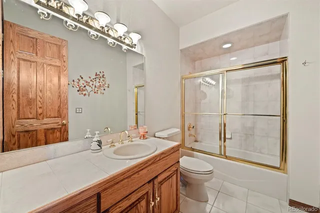 a bathroom with a granite countertop sink toilet a mirror and shower