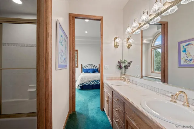 a en suite bathroom with a double vanity sink a mirror and shower