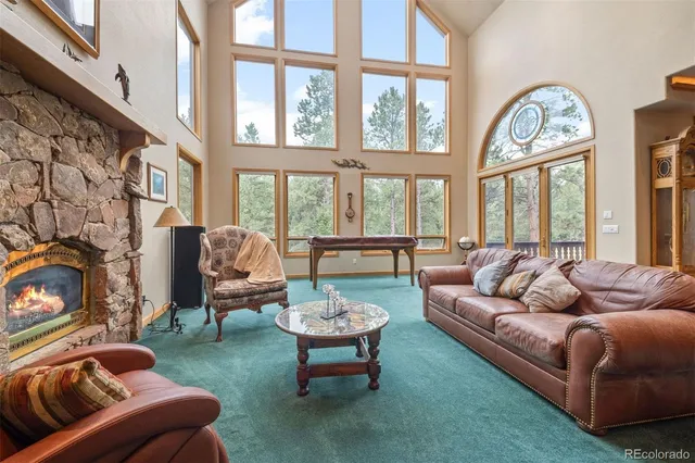a living room with furniture a fireplace and a large window
