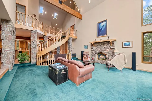 a living room with furniture floor to ceiling window and a fireplace