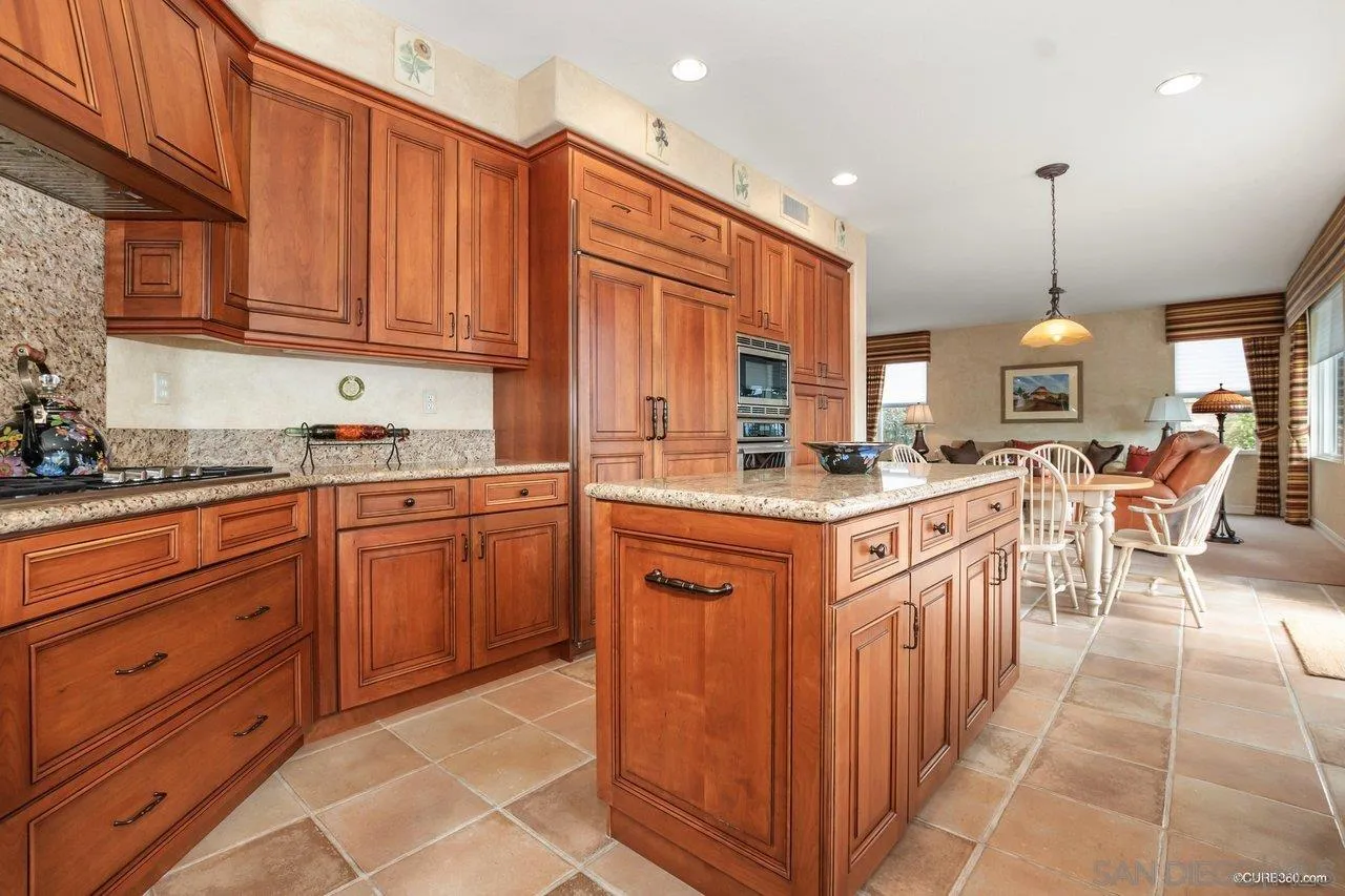 2451 Selkirk Row La Jolla, CA 92037 - Photo 14 of 37 a kitchen with stainless steel appliances granite countertop a stove a sink dishwasher and a refrigerator with wooden cabinets
