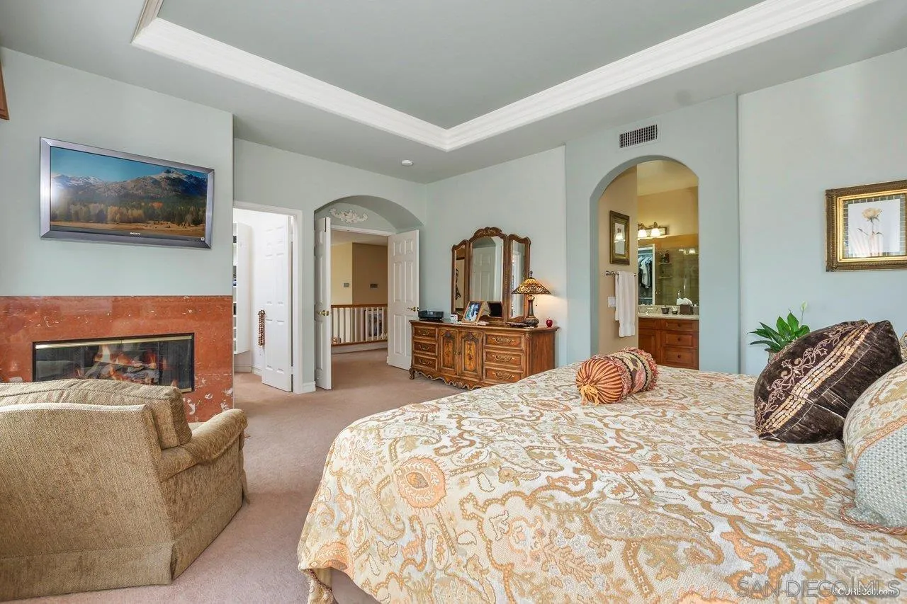 2451 Selkirk Row La Jolla, CA 92037 - Photo 16 of 37 a bedroom with a large bed and a fireplace