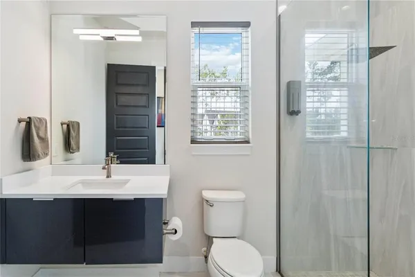 a bathroom with a sink a toilet and shower