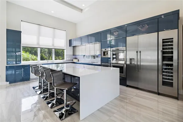 a kitchen with kitchen island a large counter top space appliances and a window