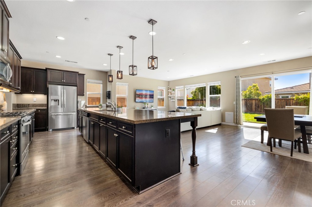 a kitchen with stainless steel appliances kitchen island granite countertop a stove and cabinets