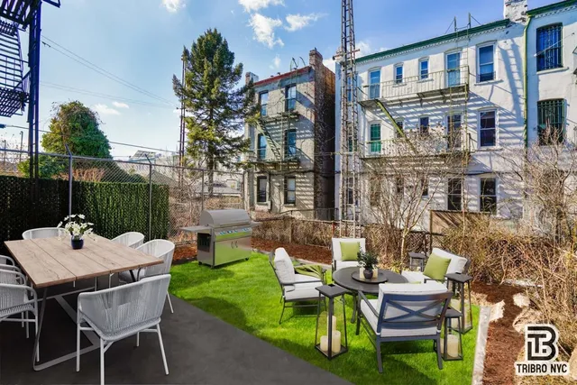 a backyard of a house with a table and chairs