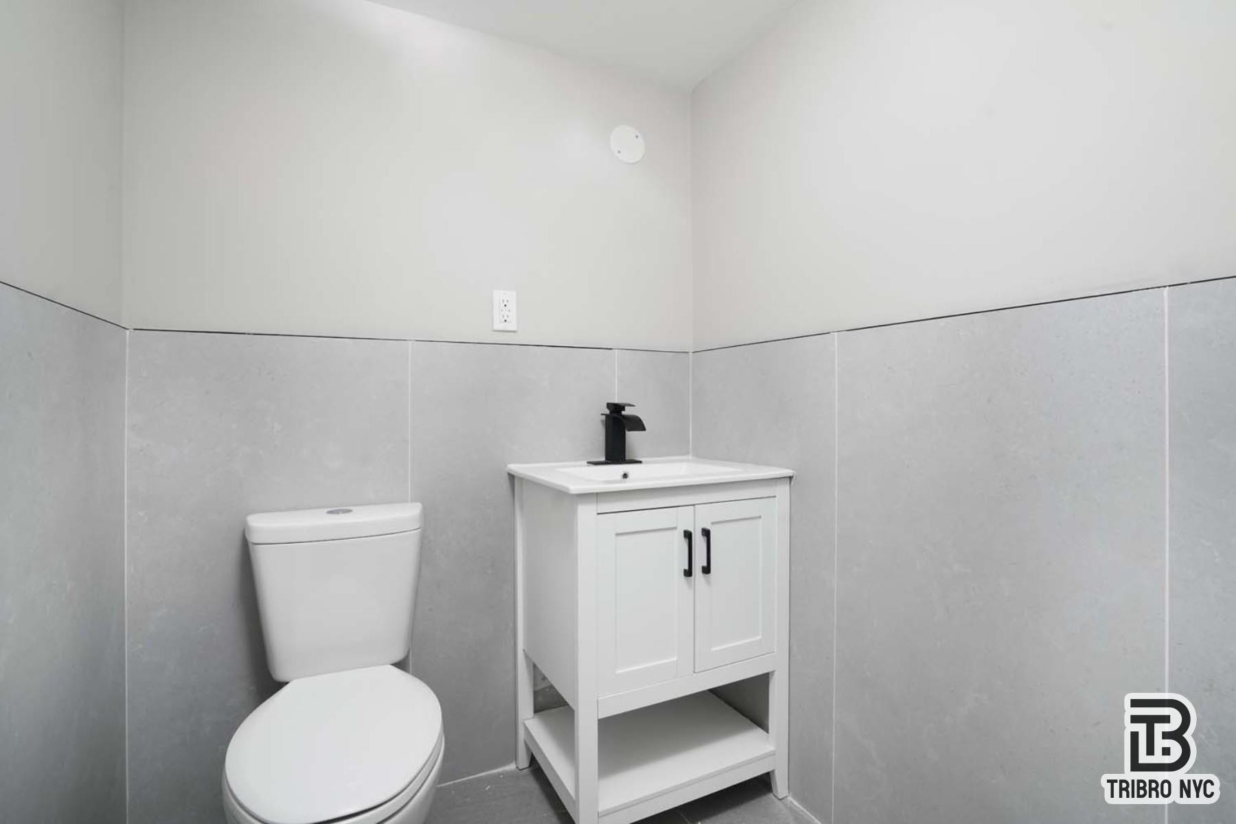 1731 Norman Street, Unit 2E Queens, NY 11385 - Photo 8 of 10 a bathroom with a sink a toilet and mirror