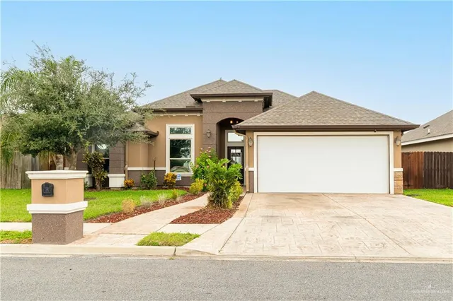 a front view of a house with a garden and yard