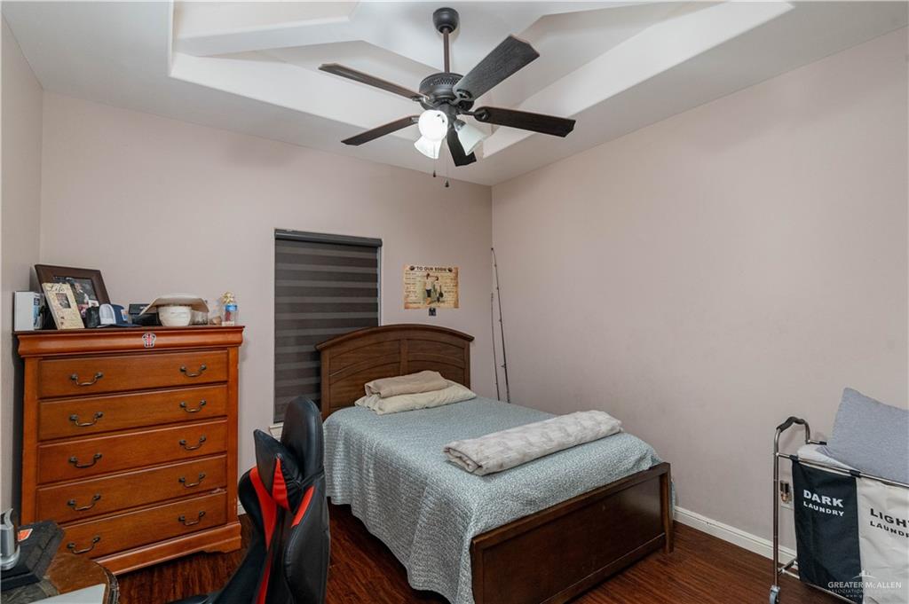 3902 Sherman Street Edinburg, TX 78542 - Photo 11 of 20 a bedroom with a bed and a chandelier