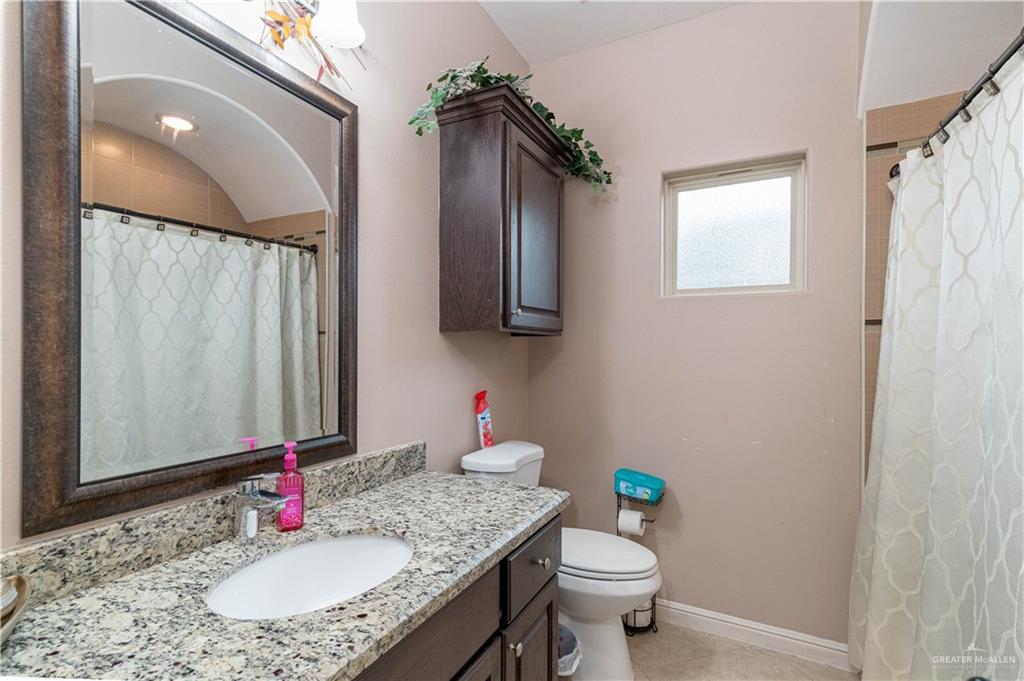 3902 Sherman Street Edinburg, TX 78542 - Photo 13 of 20 a bathroom with a granite countertop sink toilet and mirror