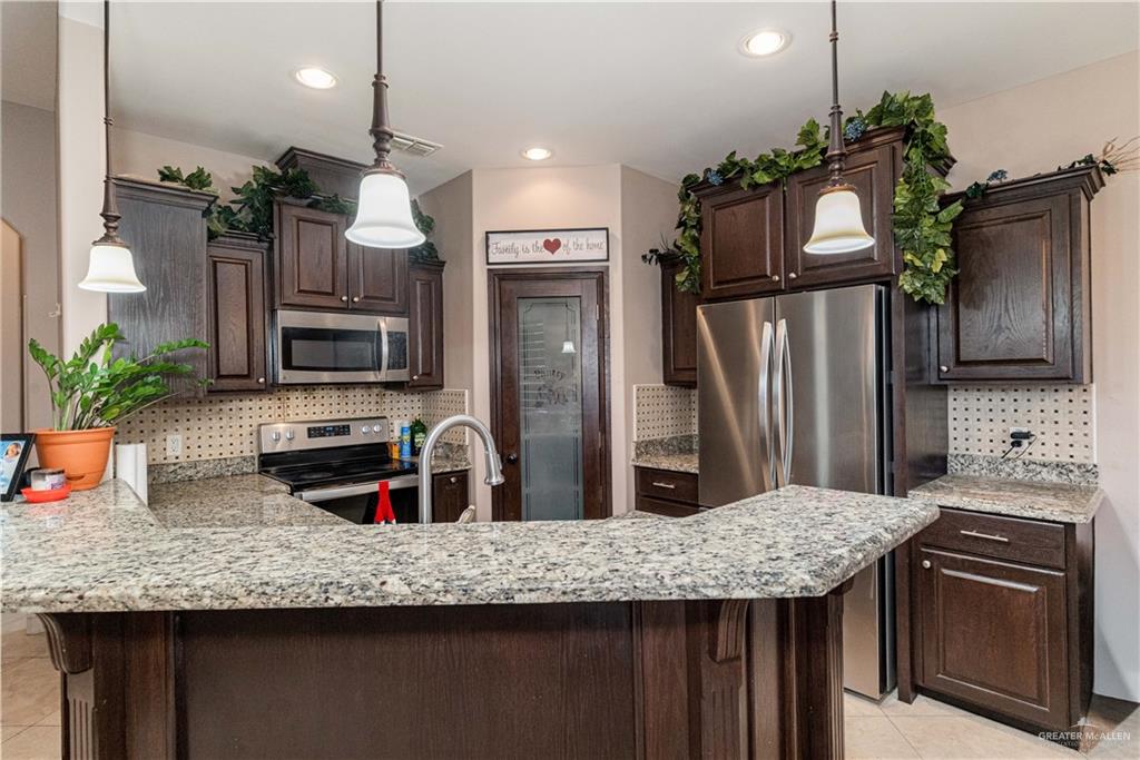 3902 Sherman Street Edinburg, TX 78542 - Photo 7 of 20 a kitchen with stainless steel appliances granite countertop a sink refrigerator and microwave