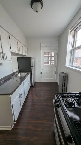 a kitchen with granite countertop a stove and a sink