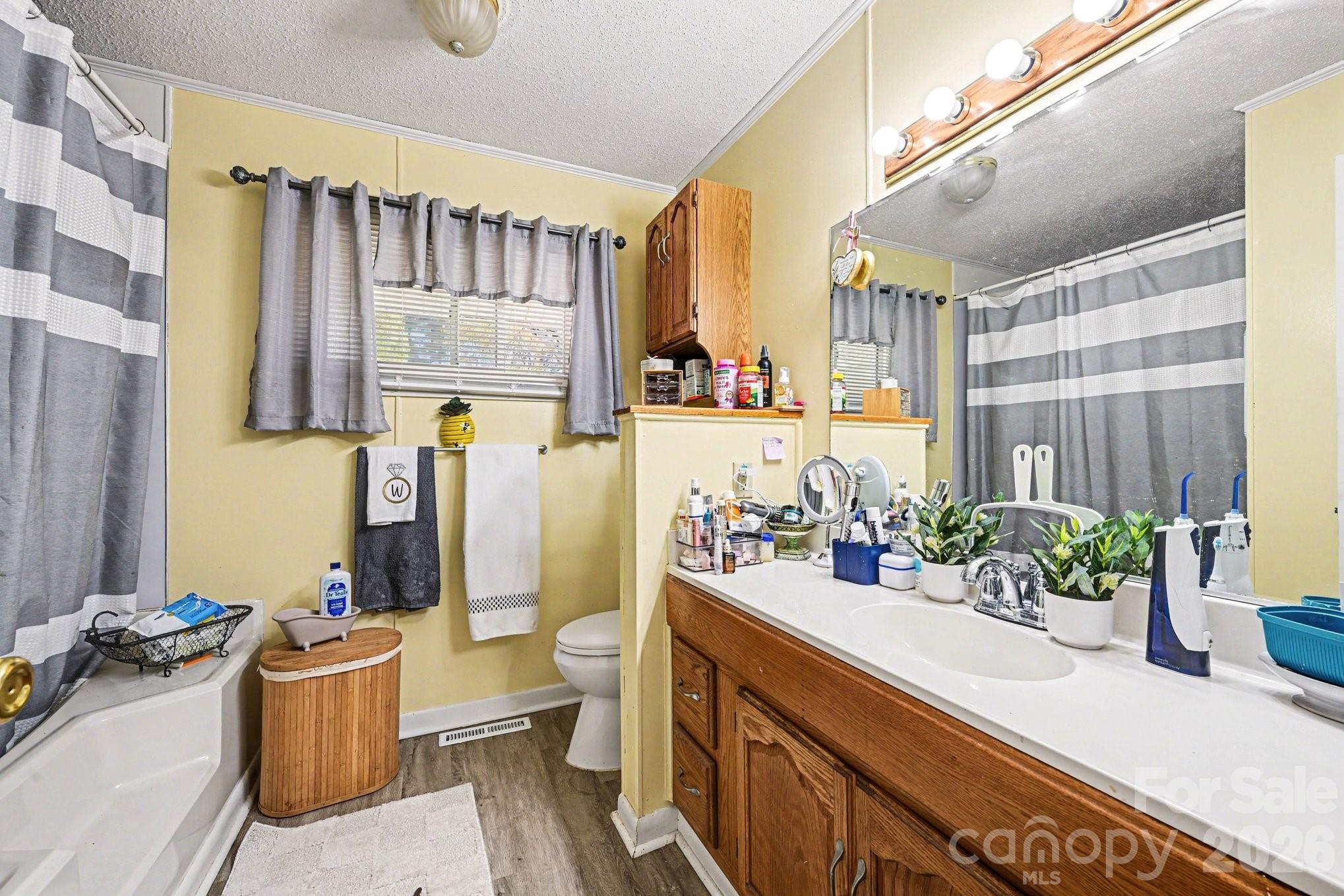 1107 Crestfield Drive Lancaster, SC 29720 - Photo 15 of 29 a bathroom with a sink a toilet and shower curtain