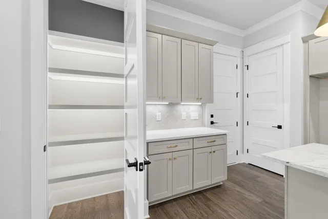 an empty room with windows and ceiling fan