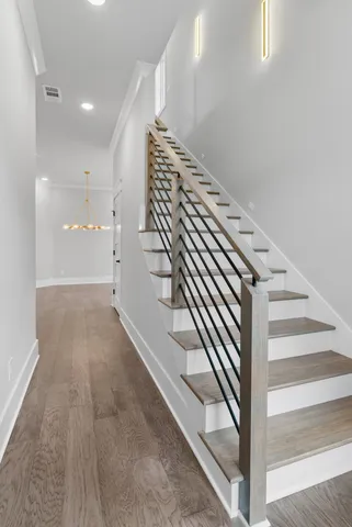 an empty room with wooden floor fireplace and windows