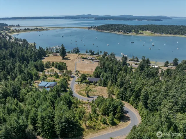 an aerial view of ocean and residential houses with outdoor space