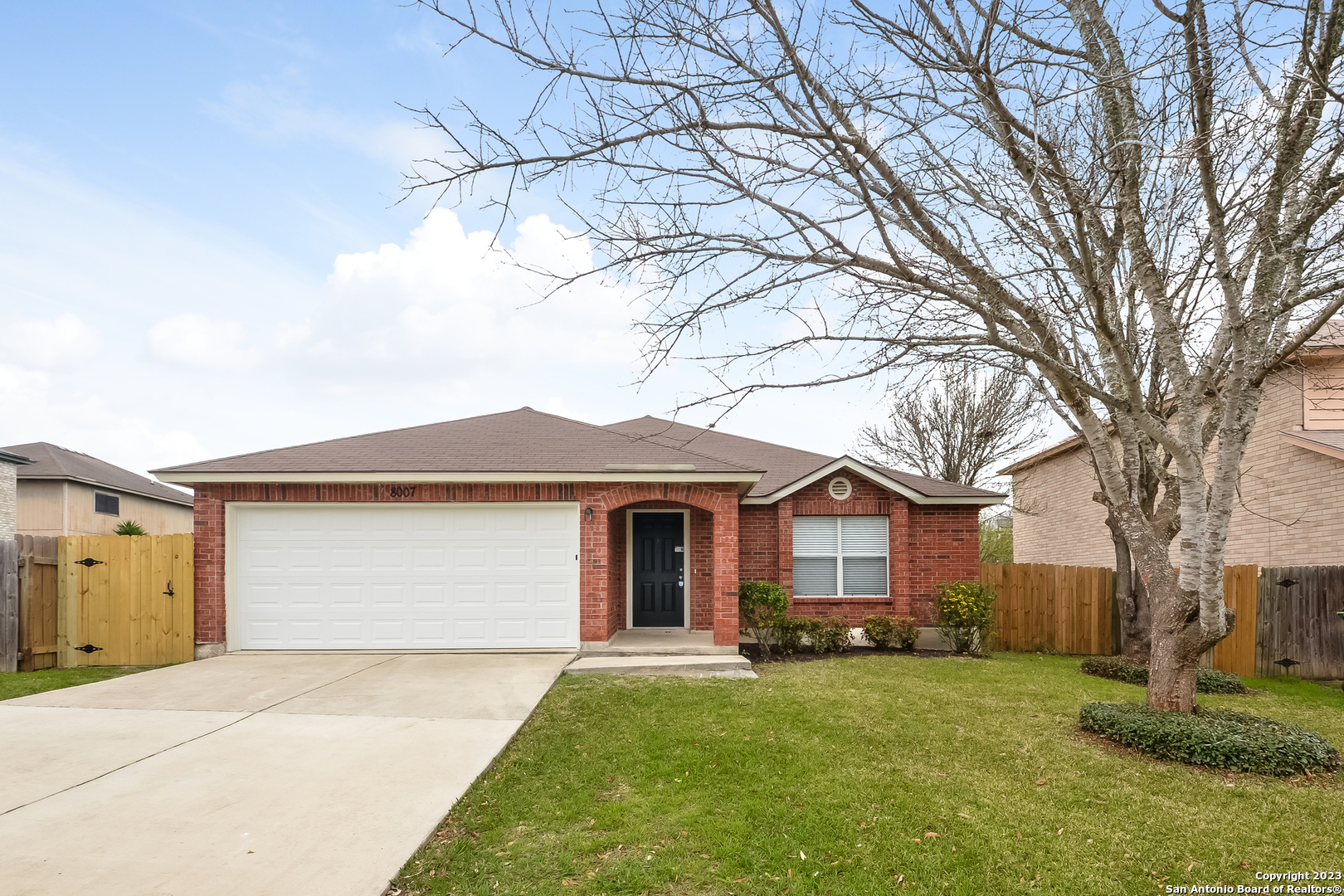 a front view of a house with a garden and trees