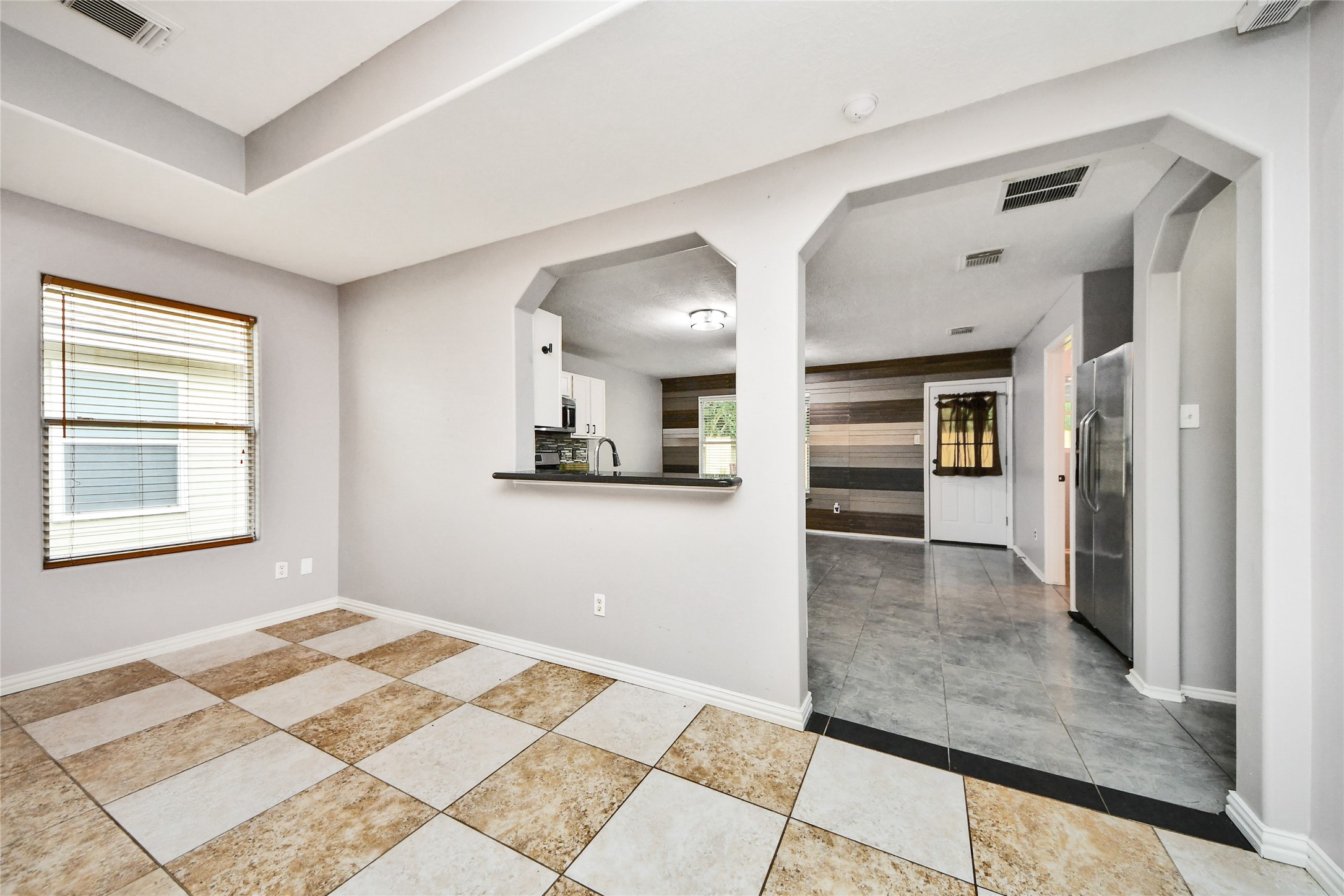 24019 Kingbriar Drive Spring, TX 77373 - Photo 13 of 41 Located just off the kitchen, this bright dining space features large-format tile flooring and a view into the living room, perfect for hosting meals with loved ones.