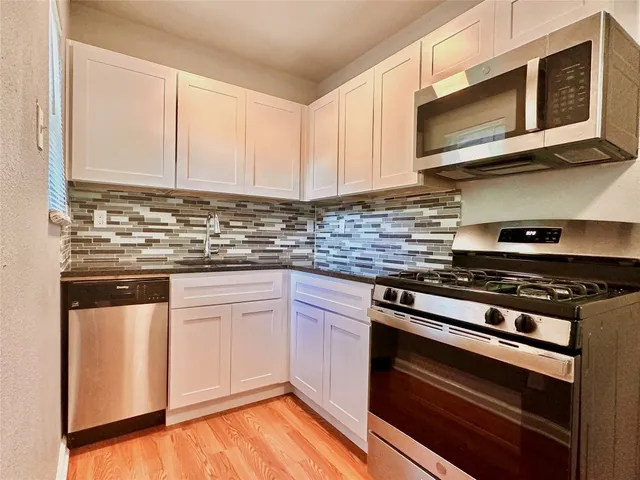a kitchen with stainless steel appliances granite countertop a stove and a microwave