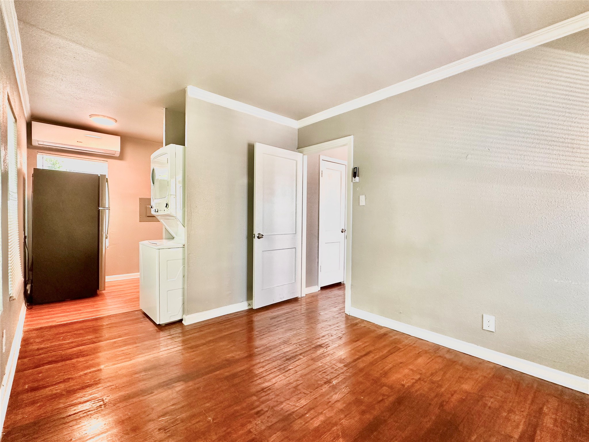 204 East 30th Street, Unit 101 Austin, TX 78705 - Photo 3 of 7 a view of an empty room with wooden floor and a bathroom