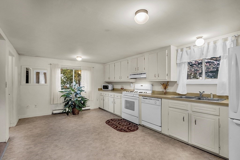 271 Broadway Haverhill, MA 01832 - Photo 10 of 26 a kitchen with white cabinets and chandelier